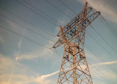 Photograph of a power line tower with the sky in the background 